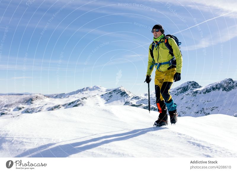 Verschneite Berglandschaft mit Reisendem Mann Berge u. Gebirge Schnee Felsen Bergsteiger Aufsteiger Gipfel Landschaft wild sonnig Rucksack aktiv Oberbekleidung