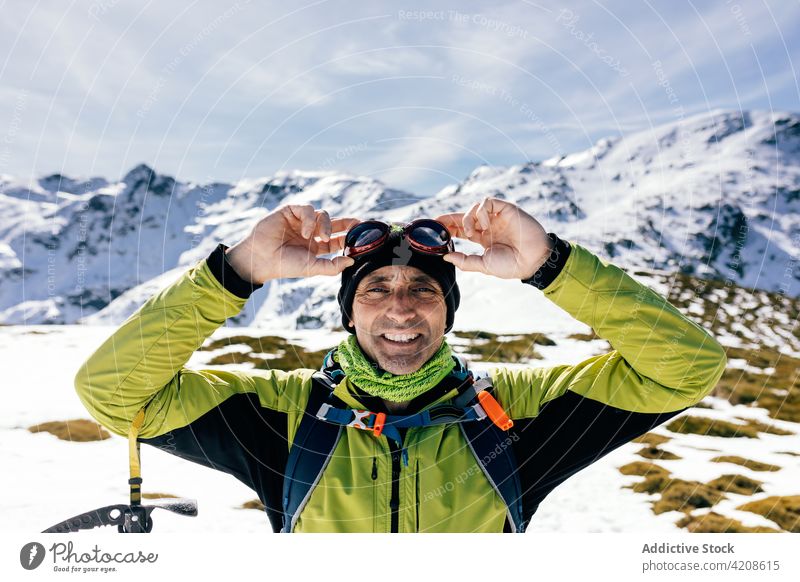 Bergsteiger beim Erkunden verschneiter Berge an einem sonnigen Tag Reisender Schnee Mann Felsen Lächeln aktiv Aufsteiger Natur Freiheit selbstbewusst