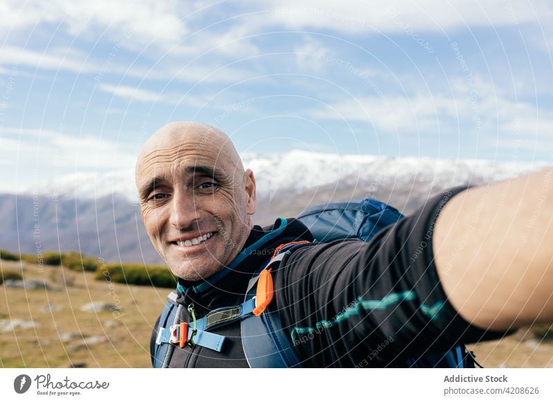 Glücklicher Reisender nimmt Selfie in verschneiten Bergen Bergsteiger Schnee Aufsteiger Mann Felsen Gipfel aktiv Berge u. Gebirge Natur Freiheit männlich