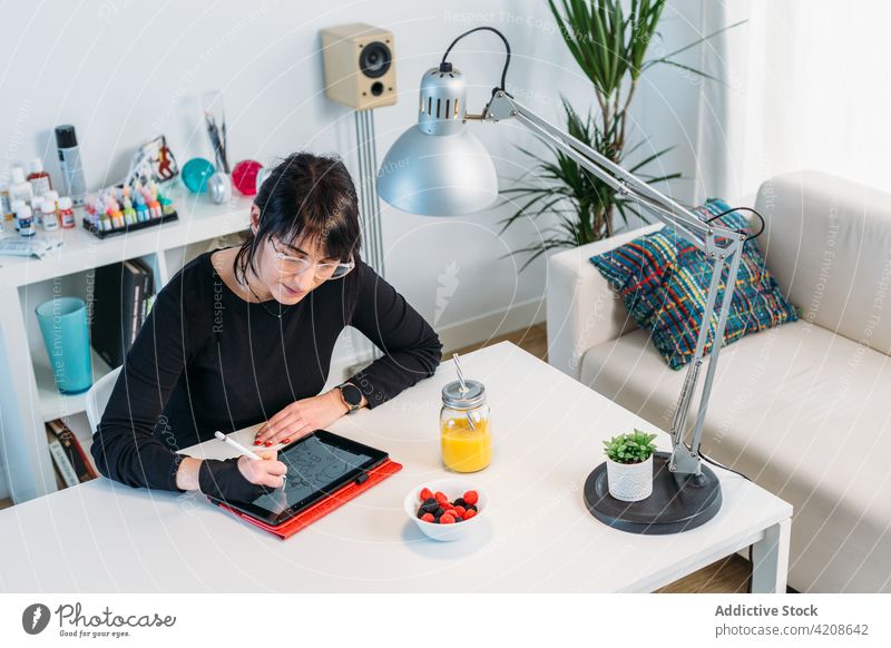 Frau zeichnet zu Hause am Tablet zeichnen Tablette Designer Künstler kreieren Kunstwerk digital Zeichner heimwärts Tisch Job Zeichnung kreativ Projekt Apparatur