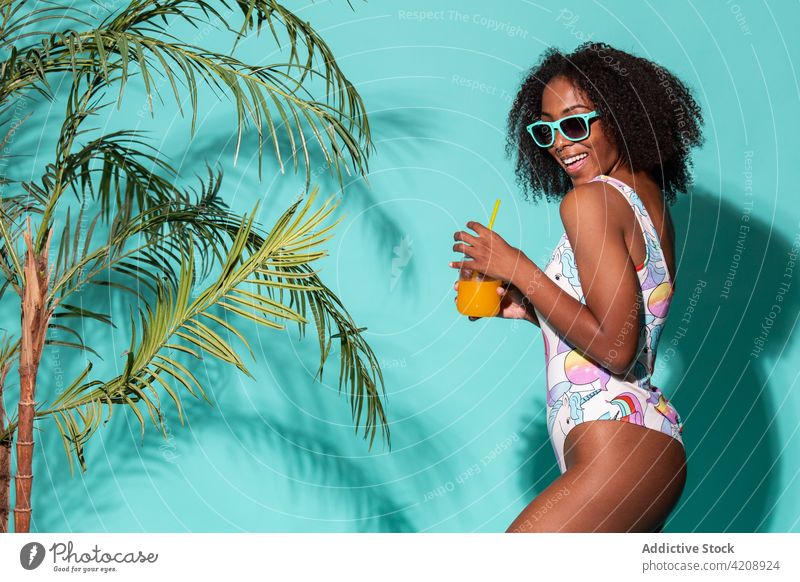 Wunderschöne schwarze Frau im Badeanzug schlürft erfrischenden Mocktail im Studio Stil Sommer trinken Erfrischung cool traumhaft genießen Glück heiter Outfit