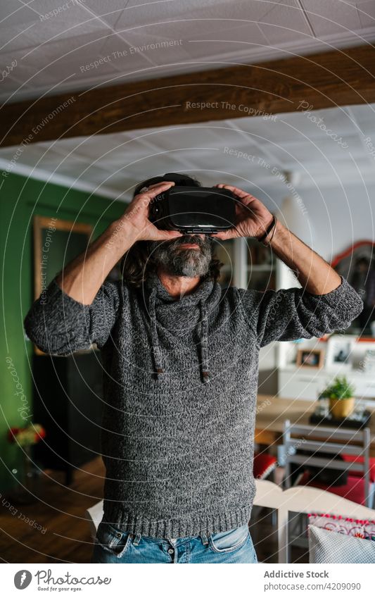 Anonymer bärtiger Mann erlebt virtuelle Realität zu Hause mit einer Schutzbrille VR Erfahrung Technik & Technologie unterhalten freie Zeit Wochenende heimwärts