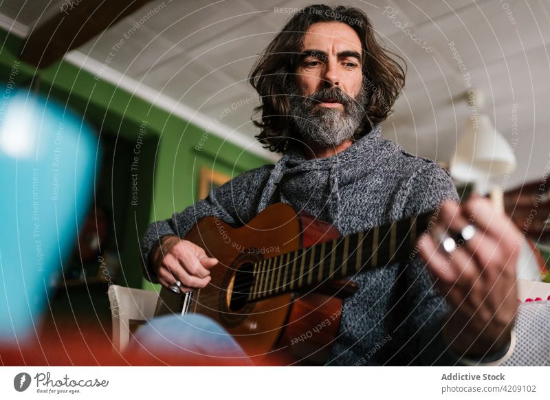 Älterer hispanischer Musiker stimmt Gitarre zu Hause Melodie akustisch Kunst Laptop Mann heimwärts ethnisch Klang Musical Instrument klassisch Netbook Stativ