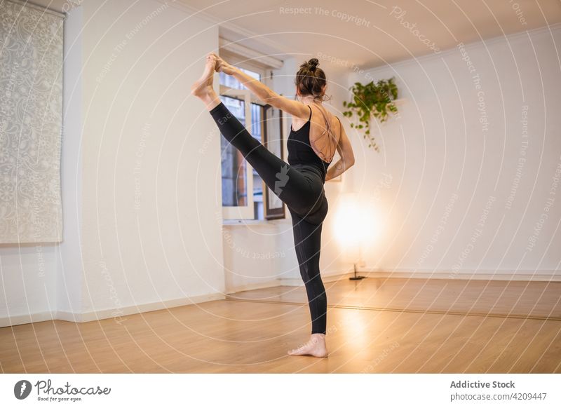 Gesichtslose Frau, die ihr Bein ausstreckt, während sie Yoga auf dem Boden praktiziert üben Dehnung beweglich erweitertes Stehen von Hand zu Fuß Gleichgewicht
