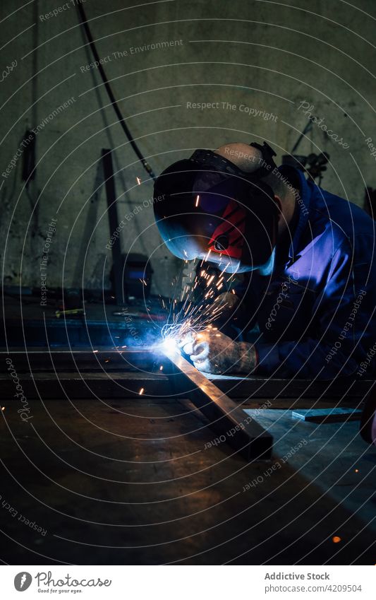 Anonymer Arbeiter beim Schweißen einer Metallkonstruktion in einer Werkstatt Person Schweißnaht Handwerker Funken Konstruktion Gerät professionell Ingenieur
