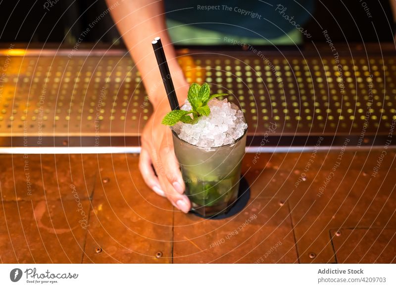 Die Hand eines unerkennbaren Barkeepers gibt dir einen gut durchdachten Mojito-Cocktail in der Bar Alkohol alkoholisch Aperitif Barista Barmann Getränk Flasche