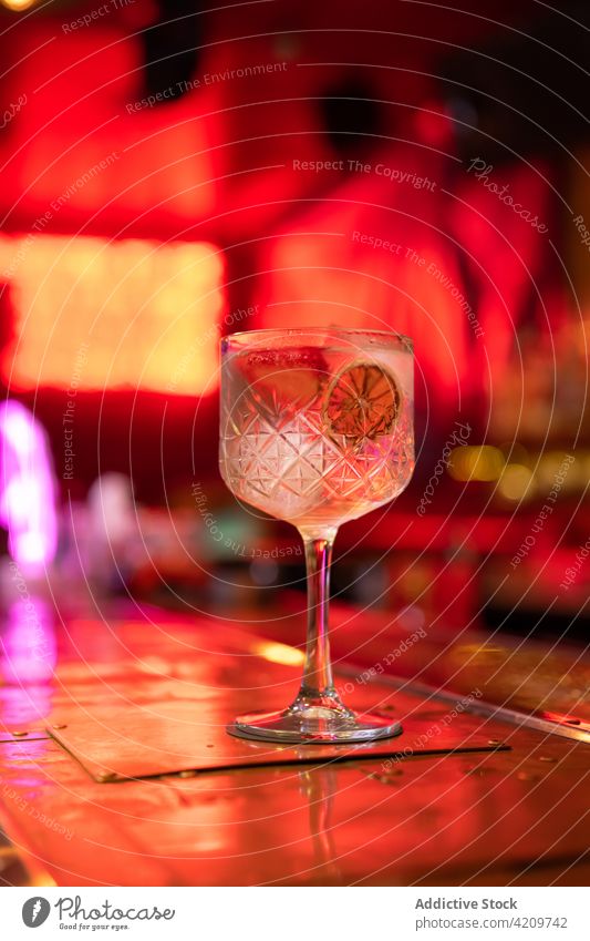 Gut durchdachter Gin-Tonic-Cocktail, dekoriert mit Erdbeeren und einem Stück trockener Zitrone an der Bar Alkohol alkoholisch Aperitif Barista Barmann Barkeeper