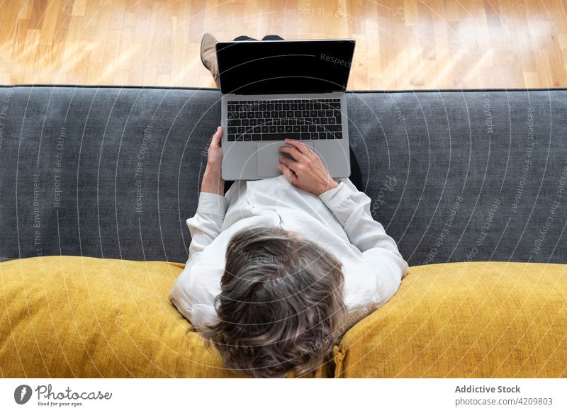 Unbekannter Fernangestellter arbeitet auf dem Sofa am Laptop Mitarbeiter Arbeit freiberuflich Touchpad Entfernung Headset Internet Frau benutzend Apparatur