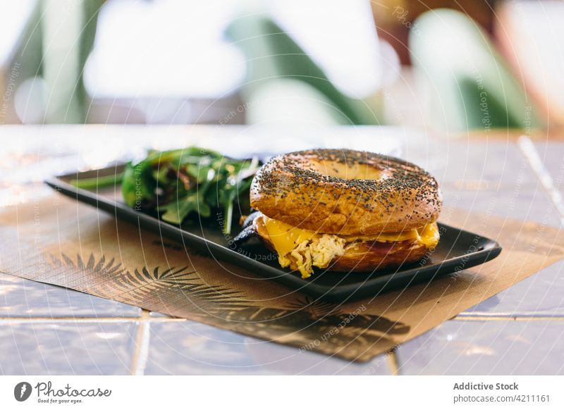 Leckeres Bagel-Sandwich auf dem Tisch im Café Belegtes Brot Fleisch dienen geschmackvoll Hähnchen appetitlich Lebensmittel Mahlzeit lecker Salatbeilage Teller