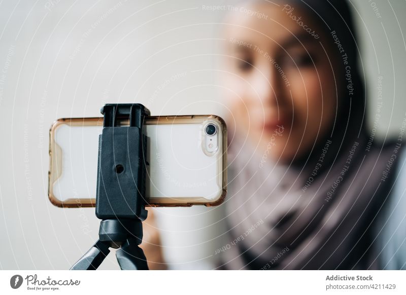 Ethnische Frau nimmt in einem Café ein Video für einen Blog auf Blogger Aufzeichnen Smartphone Influencer soziale Netzwerke benutzend ethnisch muslimisch Hijab