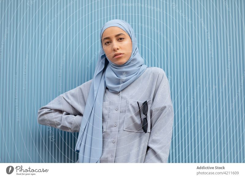 Verträumte ethnische Frau mit Kopftuch auf blauem Hintergrund Melancholie wehmütig einsam herzlich nachdenken besinnlich Islam Porträt Stil lässig modern Farbe