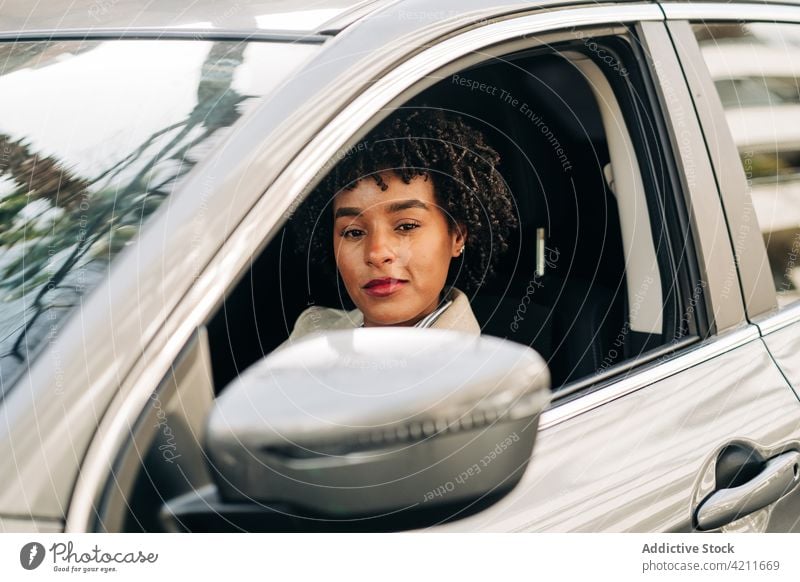 Schwarze glückliche Frau fährt Auto PKW trendy Mode Afroamerikaner Laufwerk schwarz Automobil Stil charismatisch Kleidungsstück Fahrzeug Hemd elegant sorgenfrei