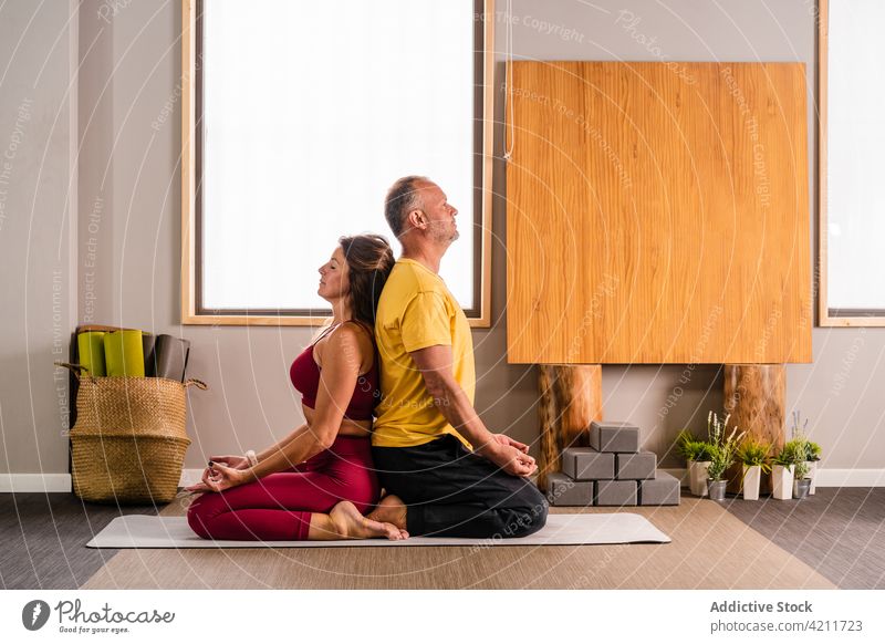 Entspanntes Paar beim Üben der Vajrasana Yoga-Pose Blitzschlag Zusammensein sich[Akk] entspannen Achtsamkeit Stressabbau Rücken an Rücken meditieren Zen
