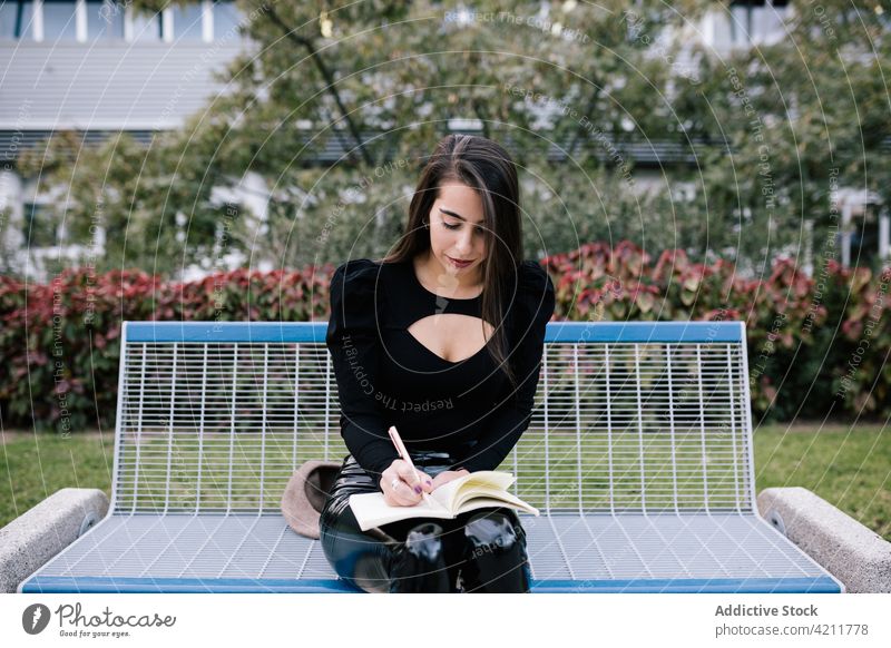 Geschäftsfrau auf einer Bank sitzend mit Notebook zur Kenntnis nehmen Park urban Großstadt Arbeit schreiben Unternehmer Frau Veranstalter Tagebuch Notizblock