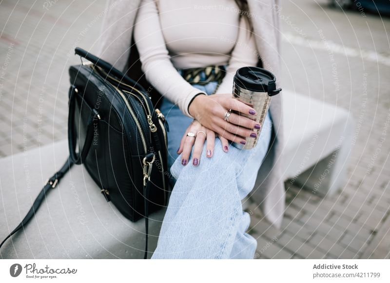 Anonyme Geschäftsfrau auf einer Bank sitzend mit Kaffee zum Mitnehmen in einer Tasse Imbissbude Großstadt trendy Unternehmer Frau Outfit Getränk trinken