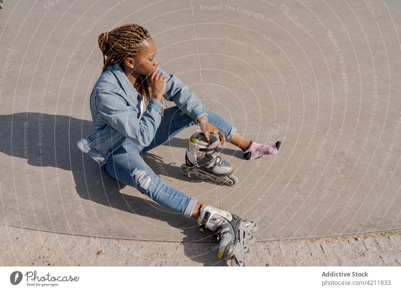 Schwarze Frau in Rollschuhen im Skatepark Rollerblade Skateplatz Sommer angezogen Park genießen Hobby sonnig ethnisch schwarz Afroamerikaner Stil Jeansstoff