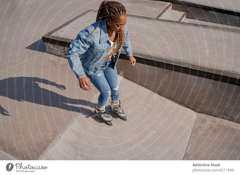 Ethnische Frau auf Rollschuhen im Skatepark Rollerblade Skateplatz Mitfahrgelegenheit sich[Akk] bewegen cool Hobby Sommer Stil ethnisch schwarz Afroamerikaner