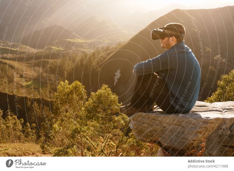 Reisende, die in den Bergen mit einer Brille virtuelle Realität erleben Reisender VR Headset Mann Berge u. Gebirge Erfahrung interagieren Schutzbrille