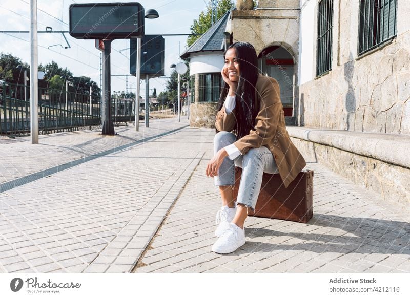 Inhalt Asiatische Frau sitzt auf einem alten Koffer am Bahnhof Eisenbahn Station warten retro altehrwürdig Reisender Podest heiter asiatisch ethnisch Ausflug
