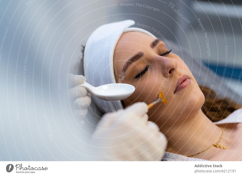 Kosmetikerin, die ein Säurepeeling auf das Gesicht einer Frau aufträgt angeblättert Schönheit Hautpflege Kosmetologie Leckerbissen abblättern Dermatologie