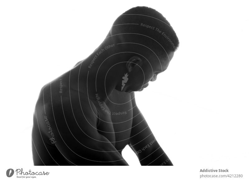 Afroamerikanischer Mann mit nacktem Oberkörper auf weißem Hintergrund Athlet muskulös sportlich emotionslos Studioaufnahme nachdenklich ohne Hemd ernst allein