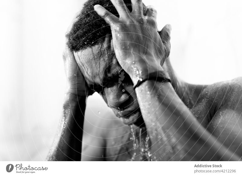 Afroamerikanischer Mann wäscht sich in der Dusche mit geschlossenen Augen Melancholie Einsamkeit drücken nachdenklich Wasser Bad unglücklich müde Waschen