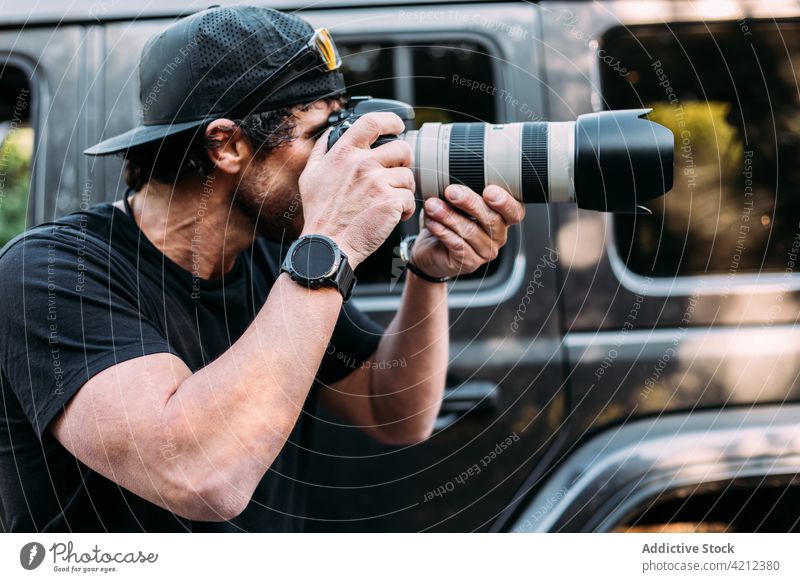 Abenteuerlustiger Fotograf macht Fotos mit seinem Geländewagen Mann Fotokamera Menschen Fotografie Erwachsener Lebensstile Natur im Freien Erkundung Transport