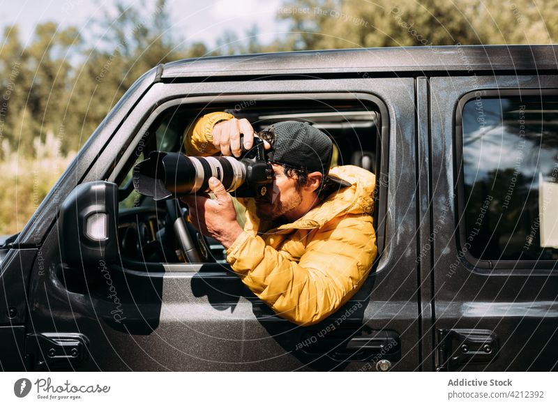 Abenteuerlustiger Fotograf macht Fotos mit seinem Geländewagen Mann Fotokamera PKW Menschen Fotografie Erwachsener Lebensstile Natur im Freien Erkundung