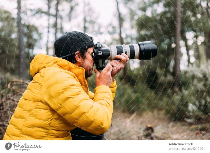 Abenteuerlustiger Fotograf beim Fotografieren in den Bergen Mann Fotokamera Menschen Erwachsener Lebensstile Natur im Freien Erkundung Transport Beteiligung
