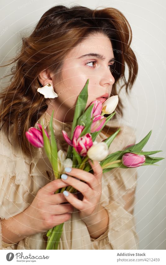 Friedliche Frau mit Tulpenstrauß im Atelier Blume Blumenstrauß Haufen Frühling ruhig friedlich romantisch geblümt frisch Flora Blüte Natur Blütenblatt Blütezeit