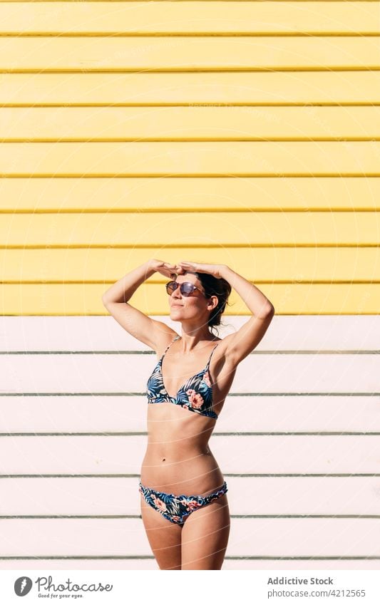 Lächelnde Frau im Bikini in der Nähe des Badekastens stehend Kasten Sommer sonnig Urlaub Sonnenbad Bräune heiter Melbourne Australien Sonnenbrille Glück