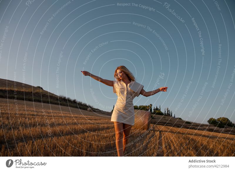 Gelassene Frau steht auf einem trockenen Feld in der Landschaft Gelassenheit friedlich sich[Akk] entspannen Wiese ländlich Sommer Harmonie Windstille Natur jung