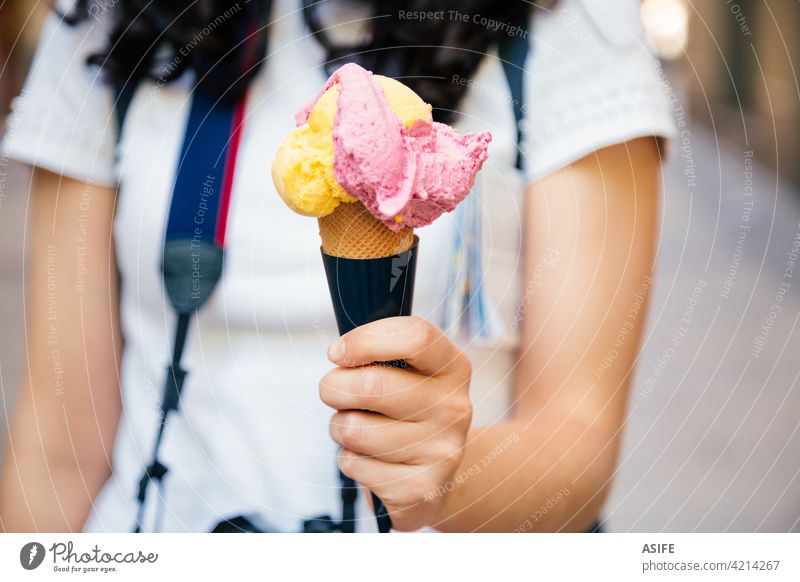 Hand eines Touristen Frau hält eine große zwei aromatisierte Eiscreme Speiseeis Zapfen Baggerlöffel Waffel Beteiligung Straße Menschen im Freien reisen Sommer
