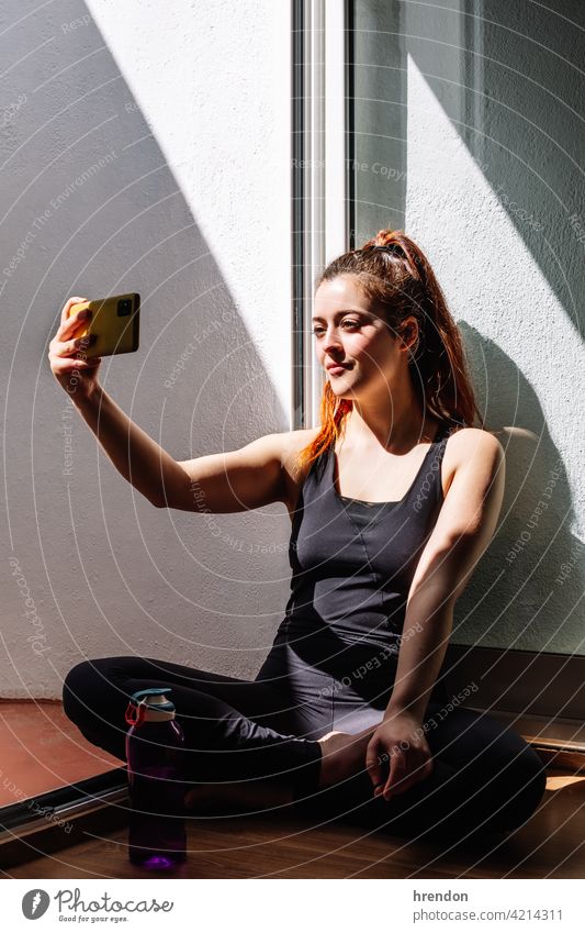 Fitness Frau sitzend und mit Mobiltelefon Raum Training passen Stock Smartphone Wohnzimmer sich[Akk] entspannen Handy Fitnessstudio entspannend Athlet Wellness