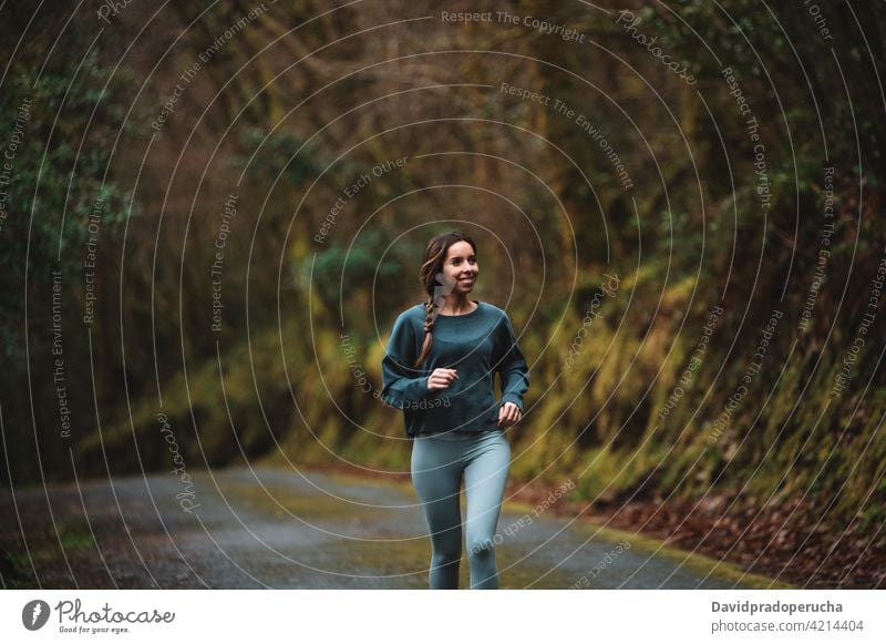 Frau läuft entlang der Straße im Wald laufen Sportlerin Training Läufer Herz sich[Akk] bewegen aktiv Energie Wälder Sportbekleidung Athlet Aktivität Gesundheit