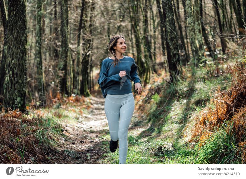 Sportliche Frau läuft im Wald laufen sportlich aktiv Training Fitness Sportkleidung passen Wälder Aktivität Läufer Sportlerin joggen Gesundheit Weg Nachlauf