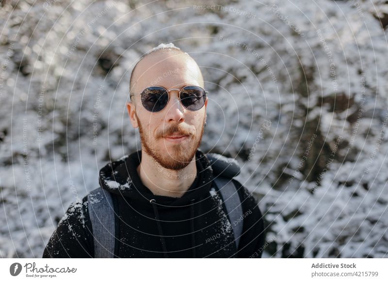 Wanderer mit Sonnenbrille vor winterlichen Bäumen während eines Ausflugs Hipster freundlich Reise natürlich Winter Mann Porträt Baum Schnee Umwelt Winterzeit