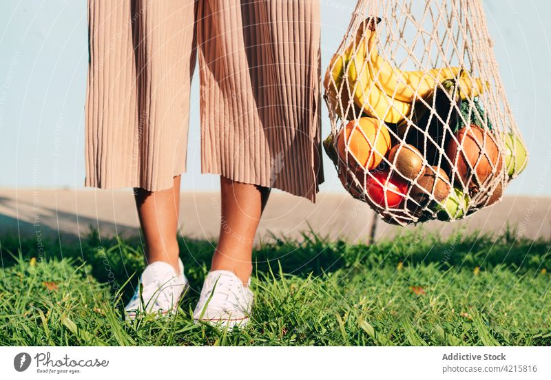 Crop-Frau mit frischen Lebensmitteln im Netzbeutel ineinander greifen Tasche Lebensmittelgeschäft umweltfreundlich Baumwolle keine Verschwendung Frucht Gemüse