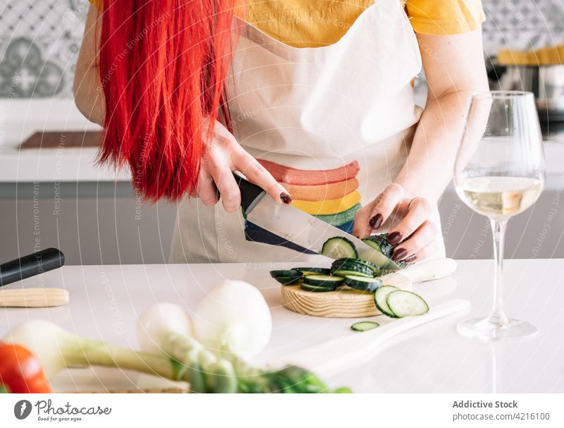 Crop lesbische Frau Schneiden Gurke bei der Vorbereitung Mittagessen zu Hause geschnitten Salatgurke gesunde Ernährung kulinarisch Rezept Gemüse Wein Küche