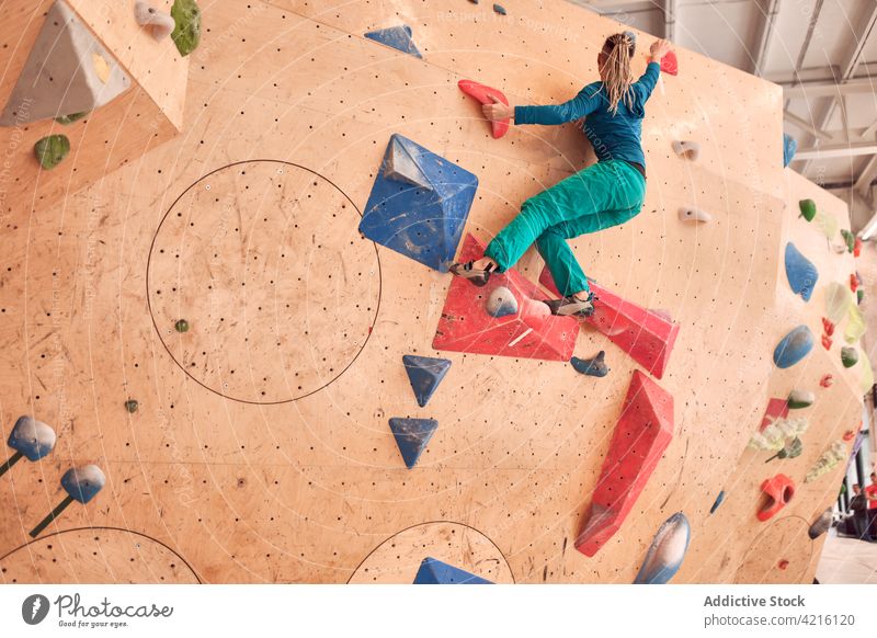 Unbekannte Kletterin klettert in einer Boulderhalle die Wand hoch Sportlerin Aufstieg Felsbrocken hängen Aufsteiger Training Bergsteiger Alpinist stark Frau