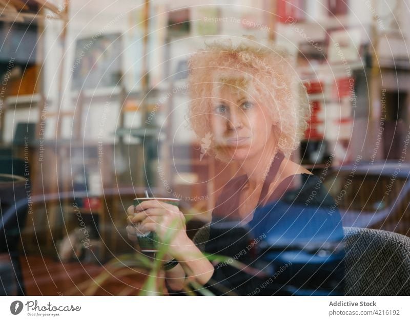 Handwerkerin in der Werkstatt sitzend mit einer Tasse Getränk Künstler Frau trinken Anstreicher Kunst Atelier Hobby kreativ Schürze Meister Kunstgewerbler