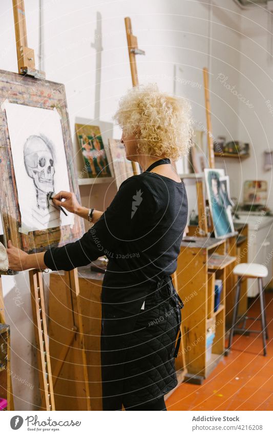 Maler, der auf einer Staffelei in einer Werkstatt auf Leinwand malt Künstler zeichnen Bleistift Skizze Frau kreativ Talent Kunst Inspiration Hobby Fähigkeit
