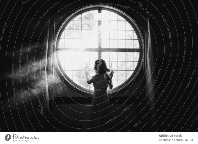 Anonyme Frau schaut bei Sonnenschein zu Hause aus dem Fenster herausschauen Einsamkeit sanft Zauberei u. Magie Angebot feminin romantisch idyllisch heimwärts