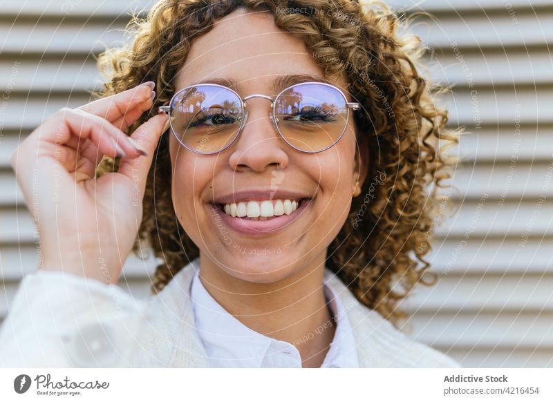 Inhalt ethnische Frau mit stilvoller Sonnenbrille in der Stadt Stil Lächeln heiter Afro-Look Frisur trendy Brille krause Haare schwarz Afroamerikaner Glück Mode