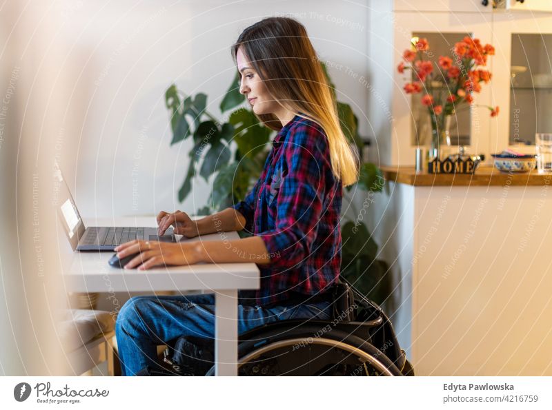 Frau im Rollstuhl benutzt Laptop zu Hause häusliches Leben Behinderung deaktiviert Selbstvertrauen unabhängig im Innenbereich heimwärts Menschen jung
