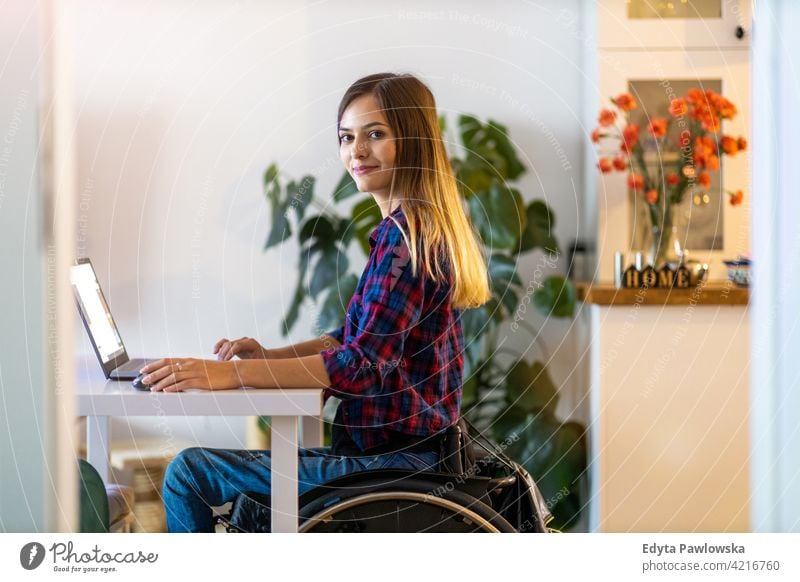 Frau im Rollstuhl benutzt Laptop zu Hause häusliches Leben Behinderung deaktiviert Selbstvertrauen unabhängig im Innenbereich heimwärts Menschen jung