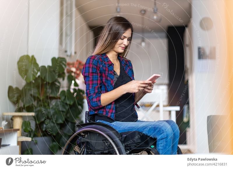 Frau im Rollstuhl auf Smartphone zu Hause häusliches Leben Behinderung deaktiviert Selbstvertrauen unabhängig im Innenbereich heimwärts Menschen jung