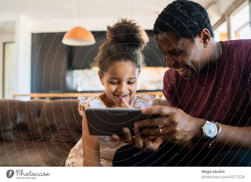 Vater und Tochter verwenden digitales Tablet zu Hause. monoparentiell spielen digitales Tablett Lifestyle Familie alleinerziehend im Innenbereich Aktivität