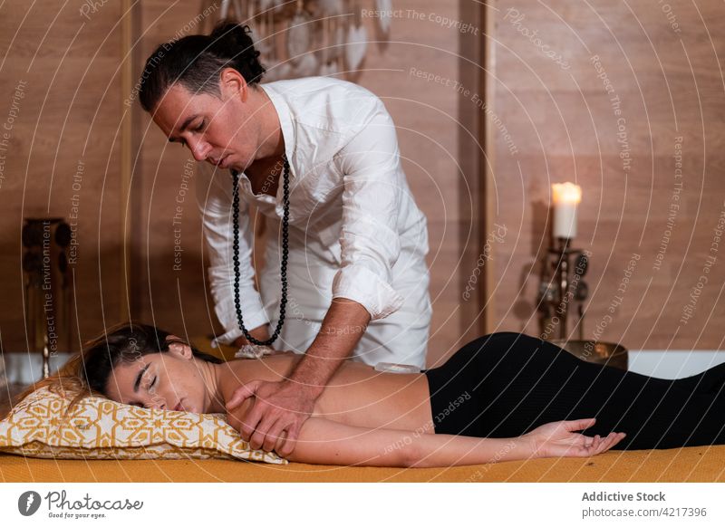Heilpraktikerin massiert ruhige Frau während der Steintherapie Praktiker Massage Zen Therapie alternativ Medizin Gelassenheit Augen geschlossen Mann