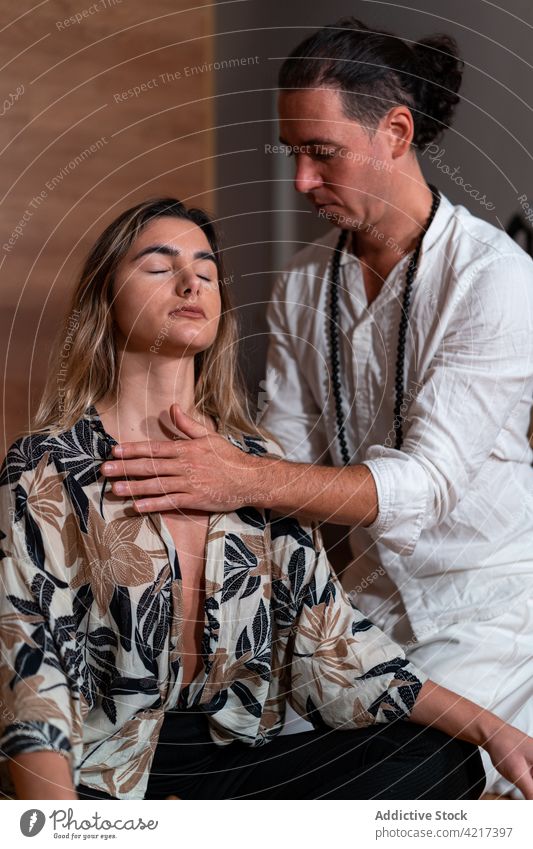 Zen-Meister mit meditierender Frau auf Plaid Lehrer Meditation Yoga üben Sprit Vitalität Stressabbau Beine gekreuzt Mann Brust berühren Energie ruhen